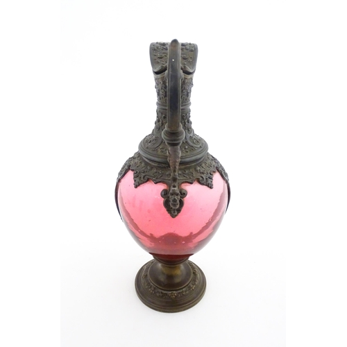 233 - A Victorian cranberry glass claret jug with decorative metal mounts and handle. Approx. 13