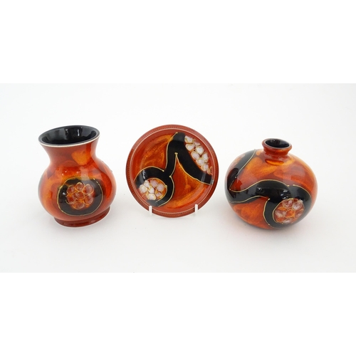 106 - Three studio pottery items by Anita Harris to include two small bases and a dish, each with a red or... 