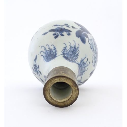 12 - A Chinese blue and white bottle vase decorated with flowers and foliage, with a metal mount. Approx.... 