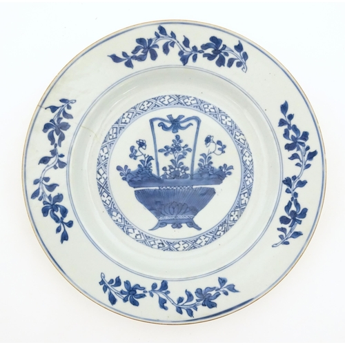 2 - A Chinese blue and white plate depicting a basket of flowers with a foliate border. With blue brushw... 