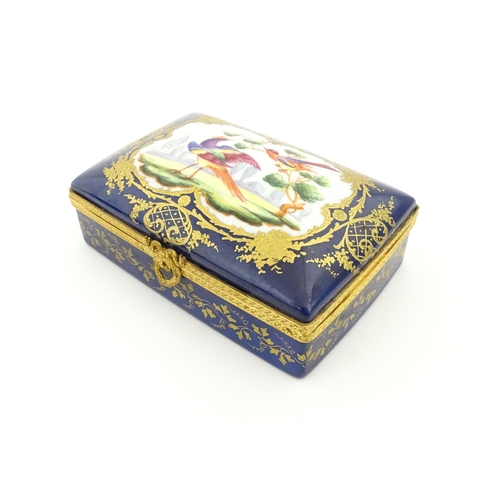 82 - A French porcelain box of rectangular form the cobalt blue ground with gilt decoration, the lid with... 