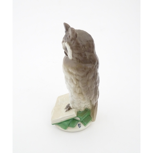 85 - A Nymphenburg model of an owl perched upon a book with the motto In Arte Voluptas. Marked under Nymp... 