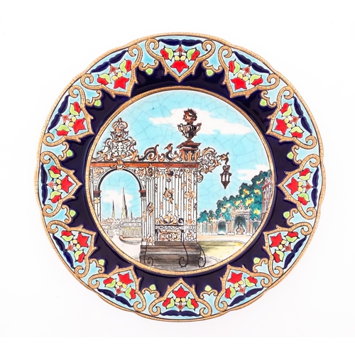 91 - A Longwy plate decorated in enamels depicting the Stanislas Gate of Nancy, France. Approx. 10