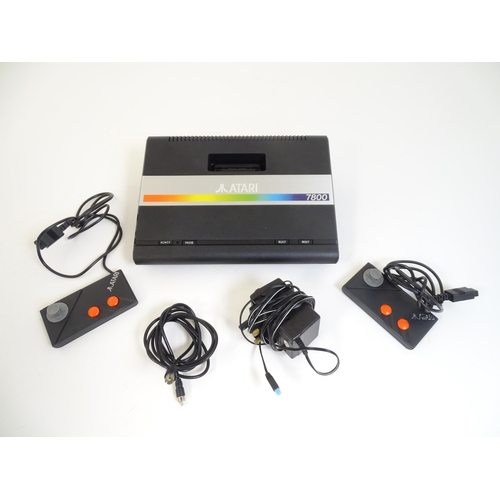 956 - Toys: An Atari 7800 video game console. Together with games cartridges comprising Jinks, Xevious, Po... 