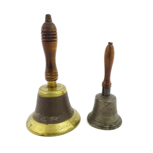 1073 - A 20thC hand bell with turned wooden handle. Together with another smaller example. Largest approx. ... 