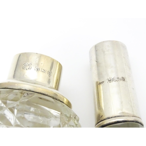 200A - Two cut glass scent / perfume bottles with silver mounts, one hallmarked Birmingham 1921, maker A J ... 