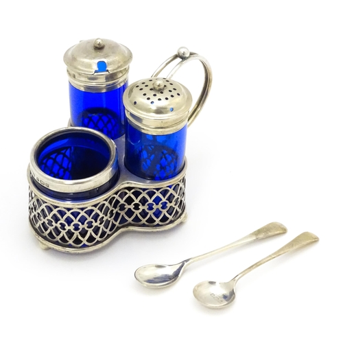 244 - A silver cruet set with blue glass bottles, comprising stand, salt, pepper and mustard, hallmarked B... 