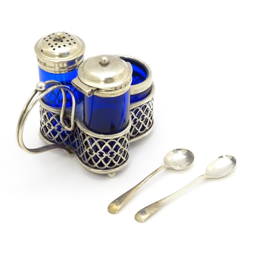 244 - A silver cruet set with blue glass bottles, comprising stand, salt, pepper and mustard, hallmarked B... 