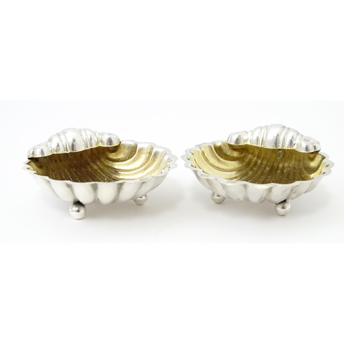 358 - A pair of silver salts of scallop shell form with gilded interiors with two salt spoons. All hallmar... 