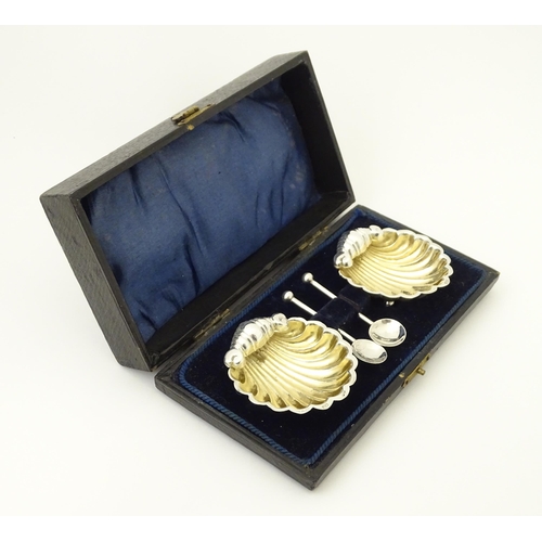 358 - A pair of silver salts of scallop shell form with gilded interiors with two salt spoons. All hallmar... 