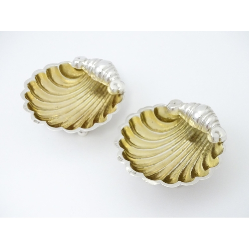 358 - A pair of silver salts of scallop shell form with gilded interiors with two salt spoons. All hallmar... 