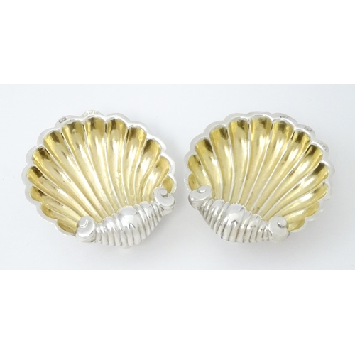 358 - A pair of silver salts of scallop shell form with gilded interiors with two salt spoons. All hallmar... 