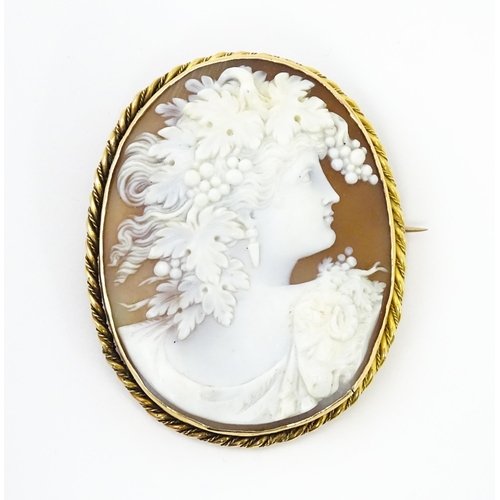 725 - A large cameo brooch with carved cameo to centre depicting bacchanalian figure within a yellow metal... 