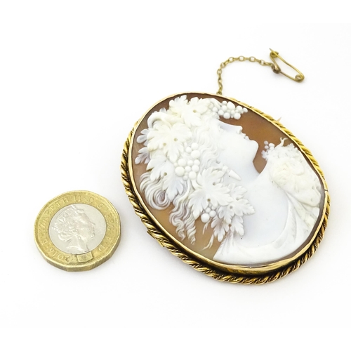 725 - A large cameo brooch with carved cameo to centre depicting bacchanalian figure within a yellow metal... 