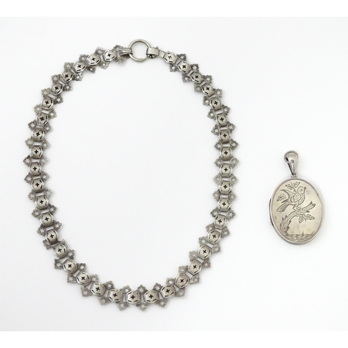 726 - A Victorian silver locket with engraved bird decoration together with a chain marked Sterling. The l... 