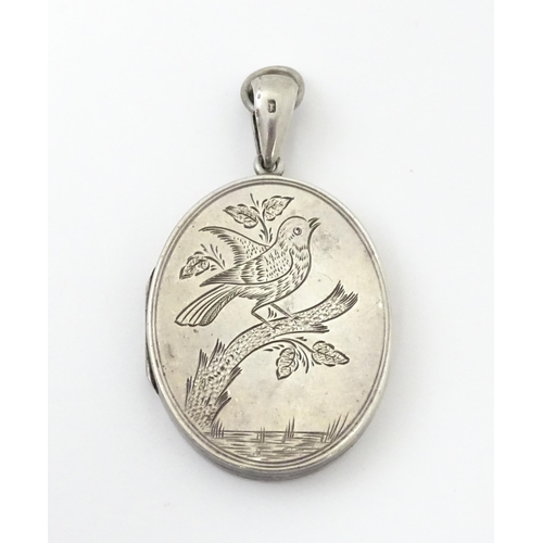 726 - A Victorian silver locket with engraved bird decoration together with a chain marked Sterling. The l... 