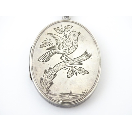 726 - A Victorian silver locket with engraved bird decoration together with a chain marked Sterling. The l... 