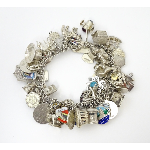 735 - A silver charm bracelet set with various silver, white metal and silver plate charms