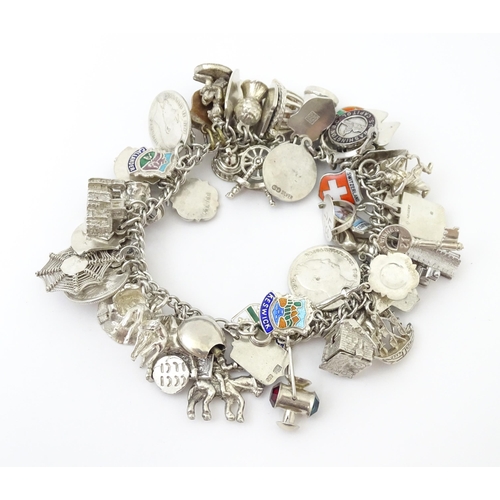 735 - A silver charm bracelet set with various silver, white metal and silver plate charms