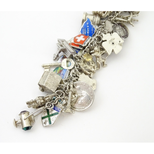 735 - A silver charm bracelet set with various silver, white metal and silver plate charms