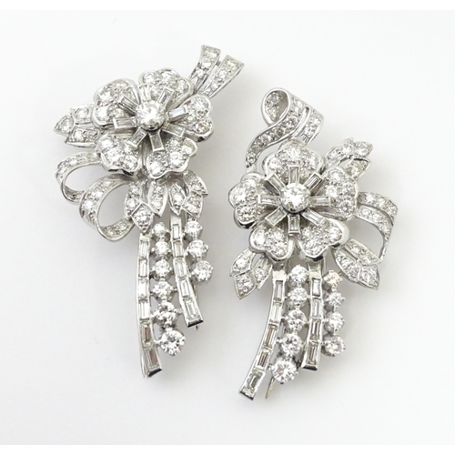 743 - A diamond double clip brooch, the clips with flower and bow detail set with a profusion of baguette ... 