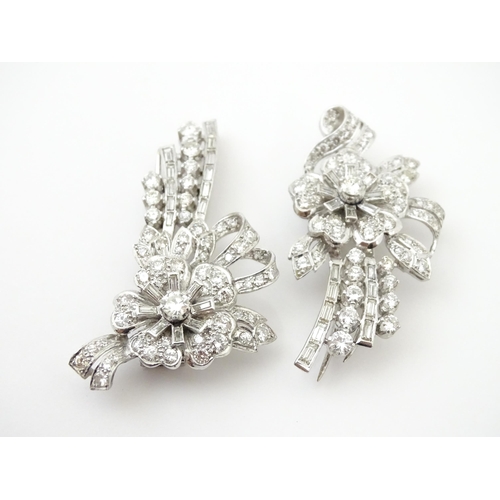 743 - A diamond double clip brooch, the clips with flower and bow detail set with a profusion of baguette ... 