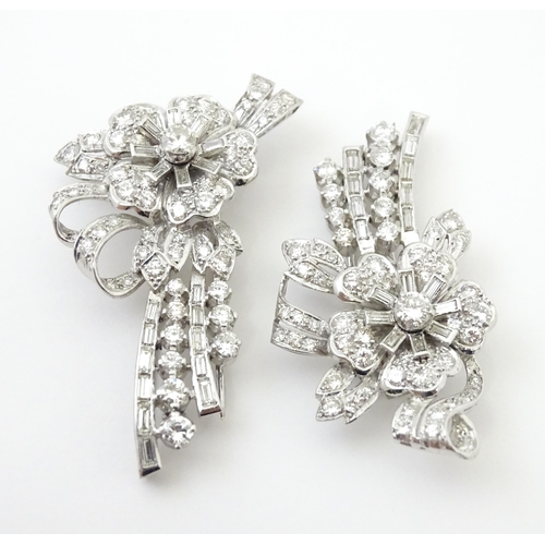 743 - A diamond double clip brooch, the clips with flower and bow detail set with a profusion of baguette ... 