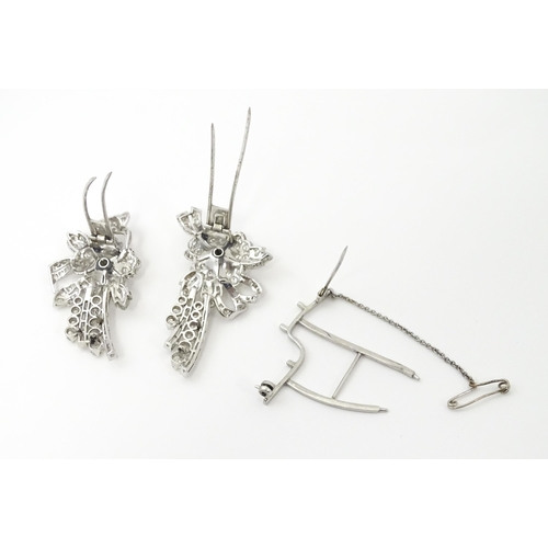 743 - A diamond double clip brooch, the clips with flower and bow detail set with a profusion of baguette ... 