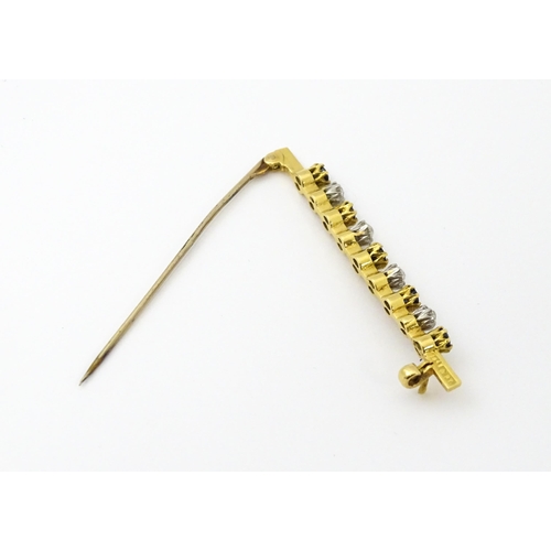 749 - A gold bar brooch with platinum set diamonds, and blue stones. Approx. 2