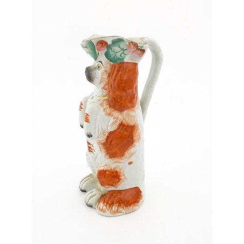 64 - A Victorian Staffordshire jug modelled as a dog wearing a hat with fruiting vine decoration. Approx.... 