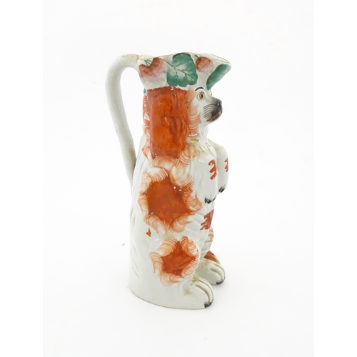 64 - A Victorian Staffordshire jug modelled as a dog wearing a hat with fruiting vine decoration. Approx.... 