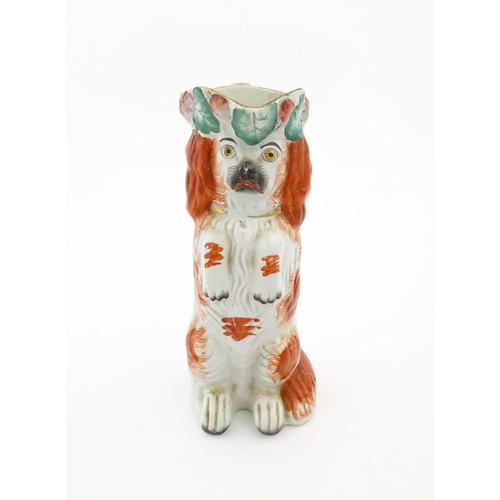 64 - A Victorian Staffordshire jug modelled as a dog wearing a hat with fruiting vine decoration. Approx.... 