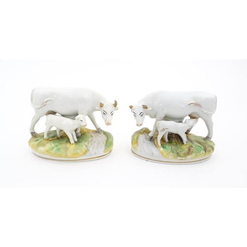 66 - Two Staffordshire models of cow and a calf. Both on oval bases. Approx. 4 1/4