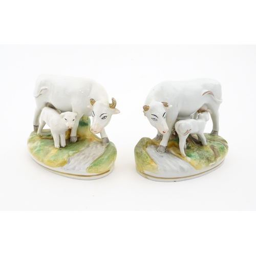 66 - Two Staffordshire models of cow and a calf. Both on oval bases. Approx. 4 1/4