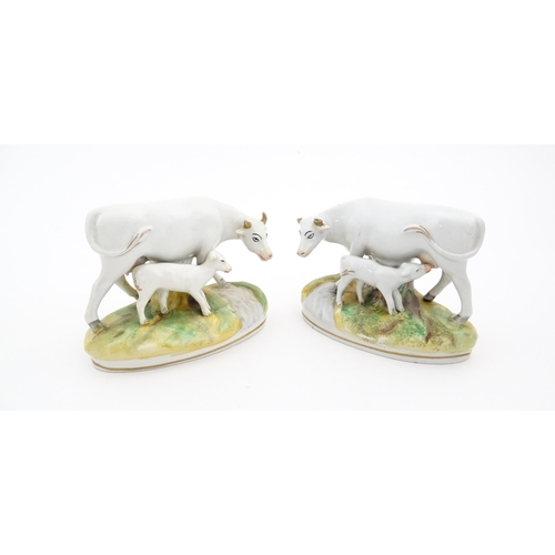 66 - Two Staffordshire models of cow and a calf. Both on oval bases. Approx. 4 1/4