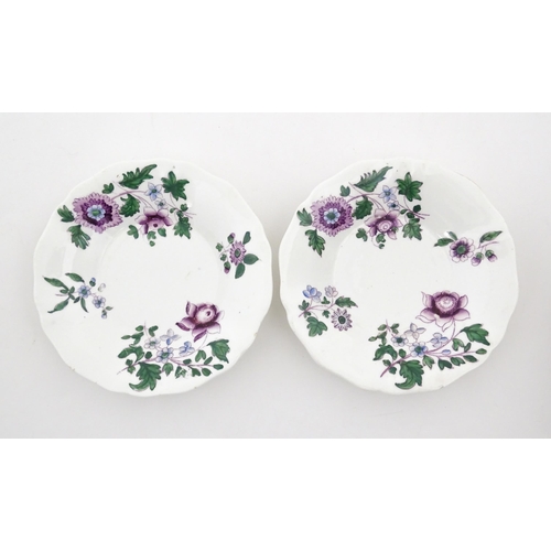 73 - A pair of Lowestoft style saucers decorated with purple and green flowers. Numbered to rim of bases ... 