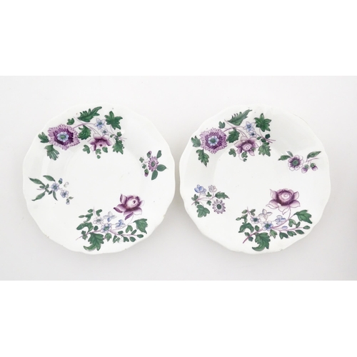 73 - A pair of Lowestoft style saucers decorated with purple and green flowers. Numbered to rim of bases ... 