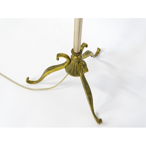 1410 - A 20thC standard lamp with triform base and foliate decoration. Together with two wrought iron style... 