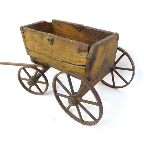 961A - Toys: A late 19th / early 20thC small wooden pull along cart with drawbar and four wheels. Together ... 