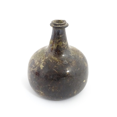 226 - A late 18thC / early 19thC English dark olive green glass onion shape wine bottle. Approx. 6