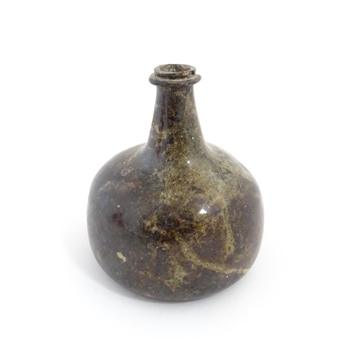 226 - A late 18thC / early 19thC English dark olive green glass onion shape wine bottle. Approx. 6