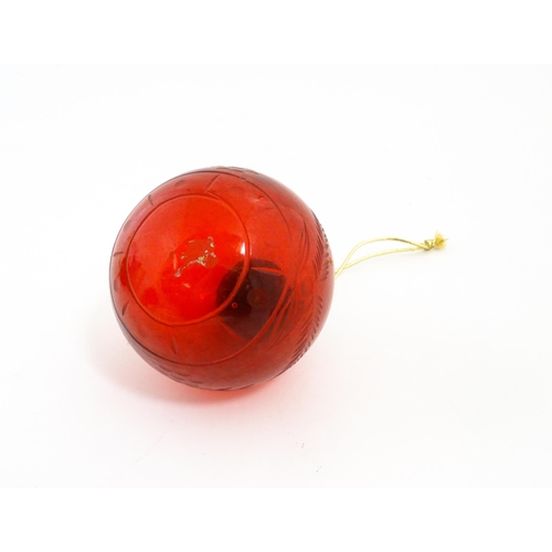 235 - Christmas decorations : Three red glass baubles with engraved detail. Largest approx. 6