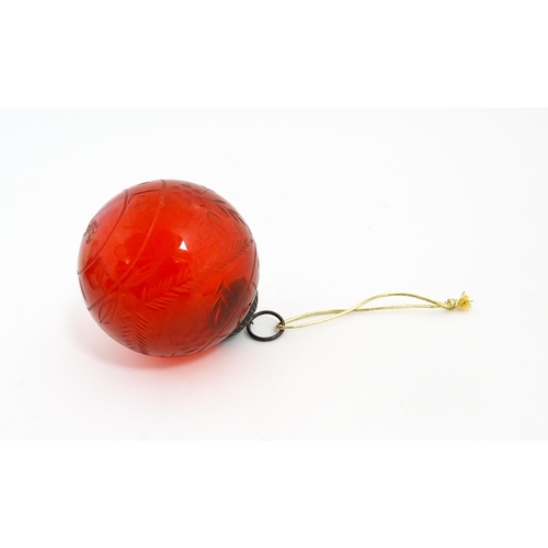 235 - Christmas decorations : Three red glass baubles with engraved detail. Largest approx. 6