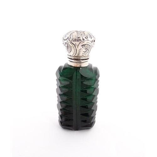 236 - A green cut glass scent / perfume bottle with stopper. Approx. 3