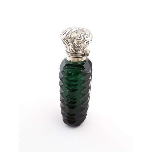 236 - A green cut glass scent / perfume bottle with stopper. Approx. 3