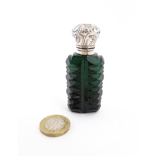 236 - A green cut glass scent / perfume bottle with stopper. Approx. 3