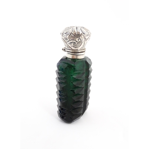 236 - A green cut glass scent / perfume bottle with stopper. Approx. 3