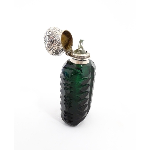 236 - A green cut glass scent / perfume bottle with stopper. Approx. 3