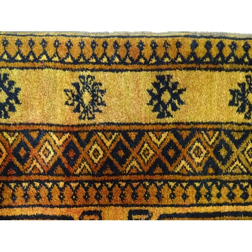 1379 - Carpet / Rug: An ochre ground rug decorated with centre vignettes with geometric motifs, further rep... 