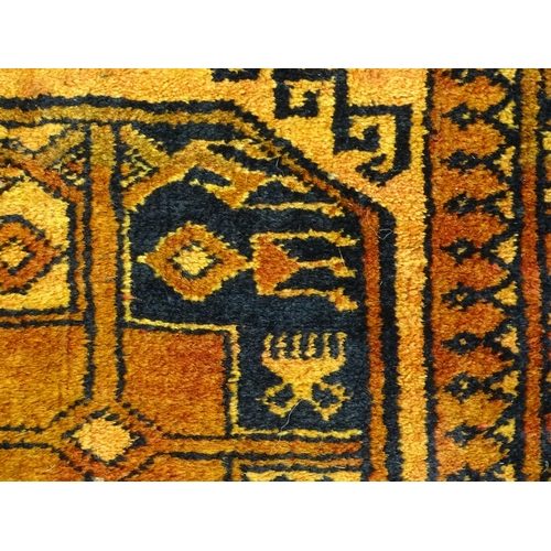 1379 - Carpet / Rug: An ochre ground rug decorated with centre vignettes with geometric motifs, further rep... 